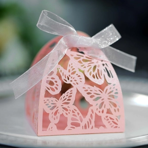 Detail of pink paper gift box with laser-cut butterfly patterns and a white silk ribbon bow