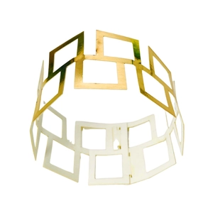 Detailed view of shiny gold geometric crown pattern on a hollow metallic napkin ring