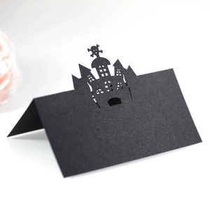 Laser-cut Halloween place card featuring a hollow black castle and skull design on paper