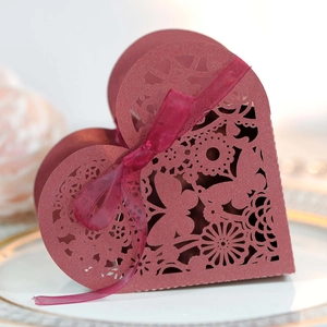 Detail of laser-cut heart candy box in dark red glitter with ribbon and butterfly pattern