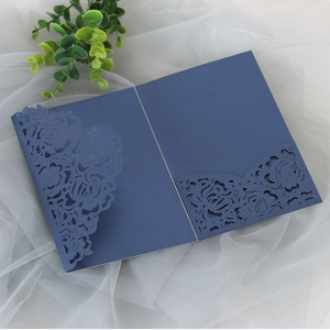 Detail of dark blue laser-cut rose floral wedding invitation with intricate hollow texture