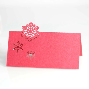 Detailed laser-cut snowflake table card in vibrant red cardstock for festive seating