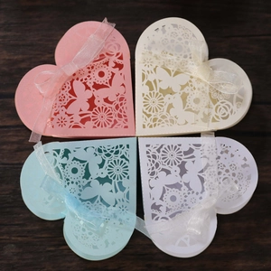 Detail of laser-cut butterfly heart gift boxes with silk ribbons in four soft colors
