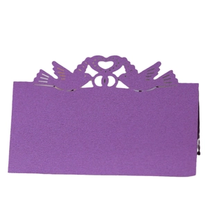 Purple laser-cut paper place cards featuring hollow heart and bird designs for weddings