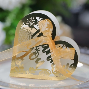 Macro shot of gold heart-shaped gift box with laser-cut floral pattern and Love text