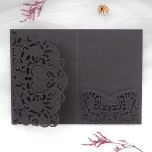 Detailed laser-cut black wedding invitation card with intricate mandala heart patterns