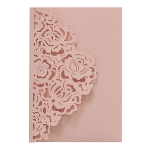 Macro shot of laser-cut rose floral details on pink matte invitation card paper