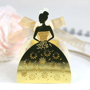 Macro detail of laser-cut gold mirror favor box with elegant girl silhouette and ribbon