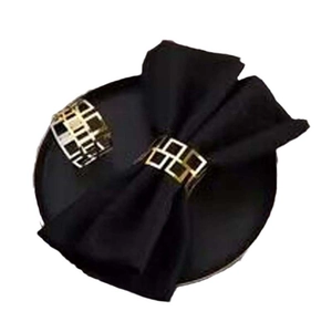 Close-up of black satin bow napkin ring with elegant gold lattice texture metal buckle