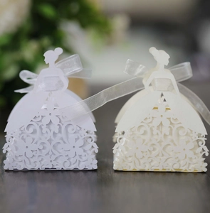 Detail showing laser-cut wedding dress favor boxes with delicate floral hollow patterns