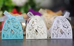 Macro shot of laser-cut butterfly gift boxes with ribbons for weddings and parties