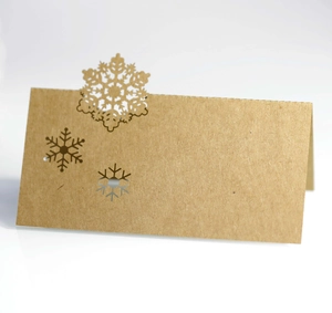 Macro shot of brown kraft paper place cards with intricate laser-cut snowflake designs