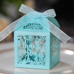 Detail of light blue laser-cut gift box with thank you text and sheer ribbon bow