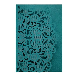 Macro detail of laser-cut damask patterns on teal European wedding invitation cover