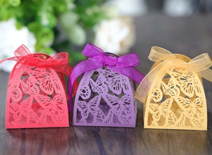 Close-up of laser-cut butterfly candy boxes with matching organza ribbons in three colors