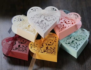 Laser-cut heart-shaped candy boxes with butterfly patterns and ribbon bows in various colors
