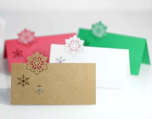 Close-up of laser-cut snowflake place cards in assorted colors for Christmas table decor