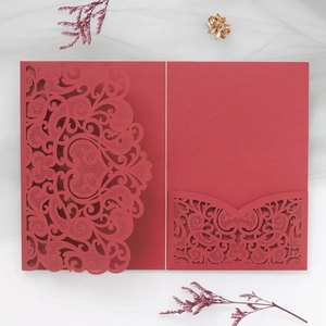 Macro detail of red laser-cut floral pattern and premium paper texture on wedding invitation