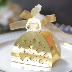 Macro shot of mirror gold wedding favor box featuring laser-cut bridal floral details