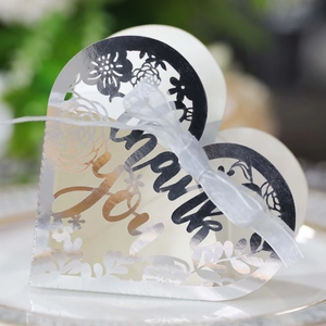 Detail of silver laser-cut floral heart favor box with Thank You engraving and ribbon