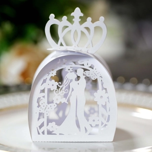 Macro shot of white laser-cut wedding candy box with bride and groom silhouette