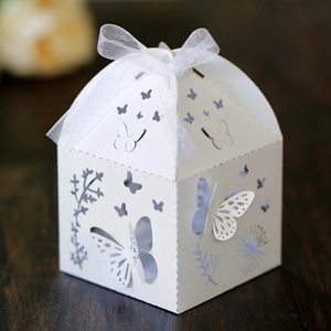 Detailed laser-cut butterfly and floral patterns on a white paper candy gift box