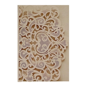 Detail view of champagne laser cut invitation card with intricate floral lace pattern