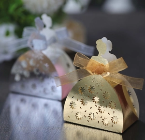 Detail of laser-cut flower patterns and sheer ribbon bow on wedding dress candy box