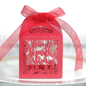 Close-up of red hollow laser-cut gift box with thank you text and silk ribbon bow