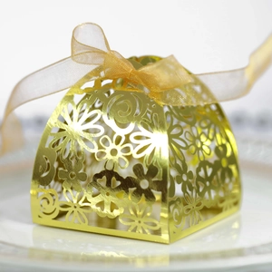 Detailed laser-cut gold wedding favor box with floral patterns and a ribbon bow