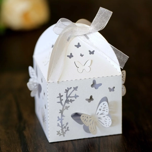 Macro shot of laser-cut butterfly hollow candy box with white organza ribbon detail