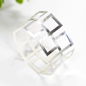 Detailed view of silver hollow geometric napkin ring with square grid pattern design