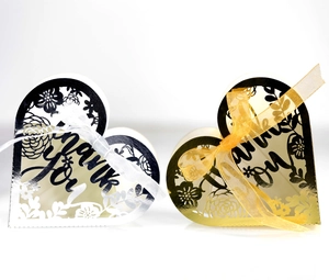 Macro detail of laser-cut heart gift boxes with silver and gold metallic texture finishes