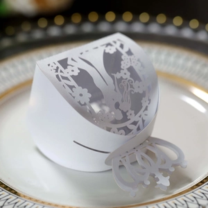 Detail view of laser-cut white wedding candy box featuring floral and butterfly patterns