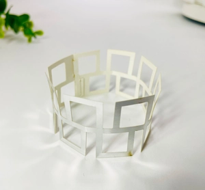 Macro view of silver geometric hollow square frame design for this metal napkin ring