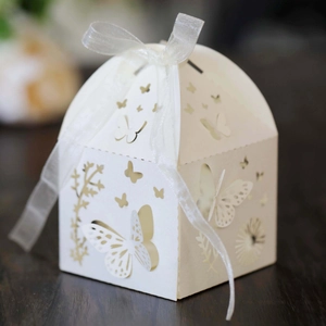 Detailed view of white laser-cut butterfly wedding favor box with a satin ribbon bow