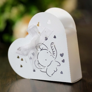 Macro di scatola regalo a cuore bianca con elefante, ritagli a cuore e nastro di seta raffinato