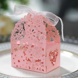 Pink laser-cut wedding favor box with floral patterns and a soft organza ribbon bow
