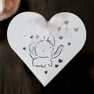 Macro di una scatola regalo a cuore bianca con stampa di elefante blu e nastro in seta