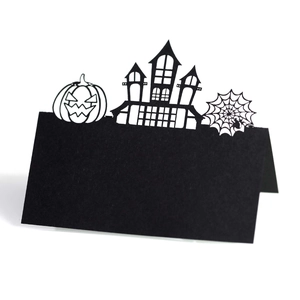 Laser cut black Halloween place card with pumpkin and castle silhouette on white background