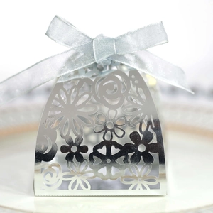Detail of laser cut floral pattern gift box with light blue ribbon on a white plate