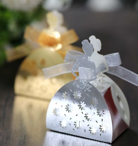 Detail of silver laser-cut bridal candy box with intricate floral patterns and ribbon
