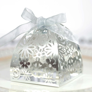 Detailed silver laser-cut wedding favor box with intricate floral patterns and blue ribbon