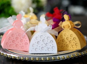 Laser-cut wedding favor boxes in dress shapes with organza ribbons and hollow patterns