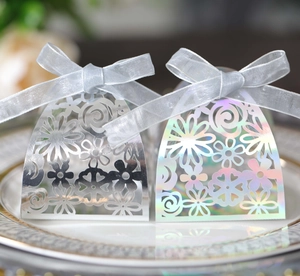 Detailed view of silver and holographic laser hollowed wedding candy boxes with ribbons
