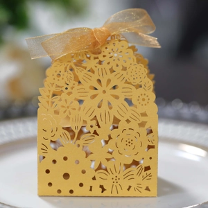 Detail of laser-cut hollow pattern and gold ribbon on European wedding candy gift box