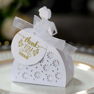 Detail of laser-cut bride silhouette wedding favor box with white ribbon and thank you tag
