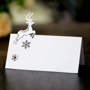 Detailed laser-cut Christmas reindeer and snowflake design on white cardstock place card