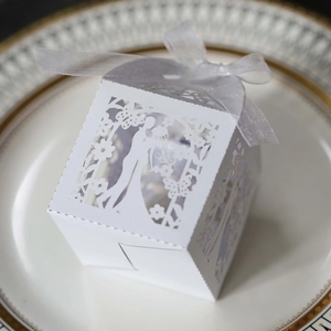 Macro detail of white laser-cut wedding favor box with bride and groom silhouette