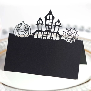 Laser cut Halloween place cards featuring black castle and pumpkin silhouettes on a plate
